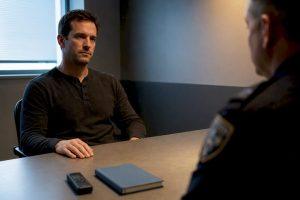 Person sitting silently in police interview room